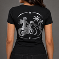 Endless Miles reflective women's motorcycle V-neck tee - back view showing woman rider on coastal road with palm trees and sunset reflective vinyl design
